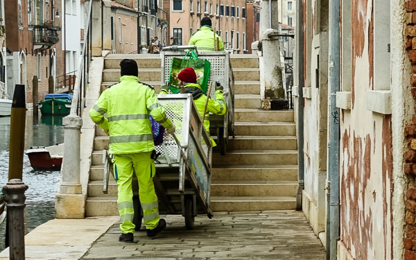 Spazzini with garbage and recycling carts on a Venice bridge.