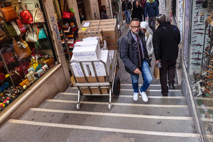 Delivery man on bridge in Venice, Italy